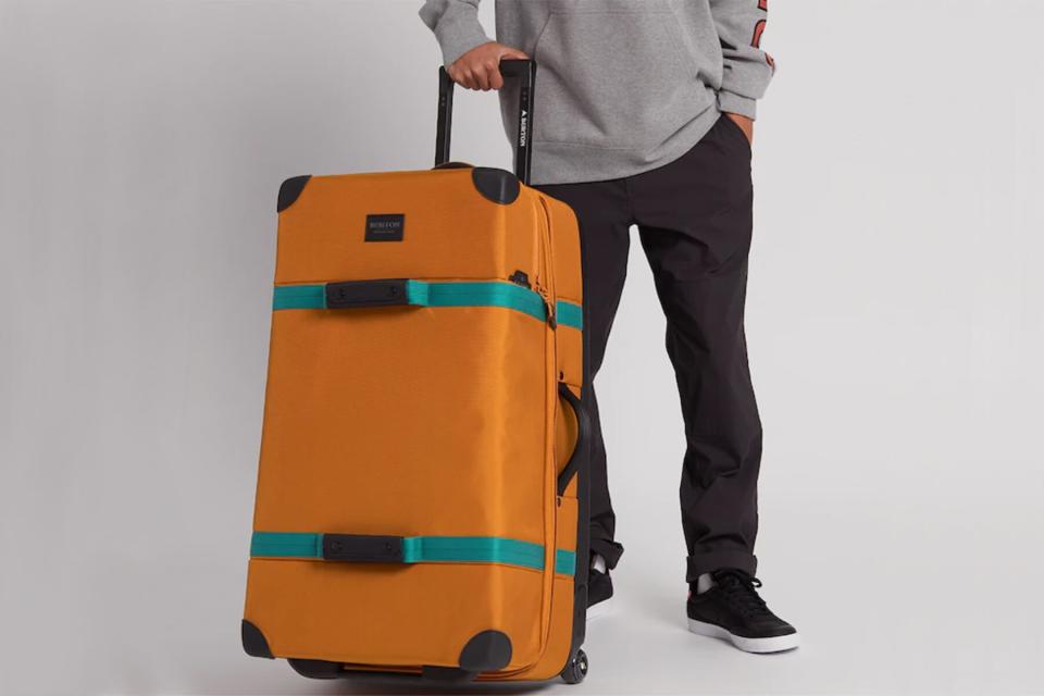 A man with the Burton Wheelie Sub 116L Travel Bag