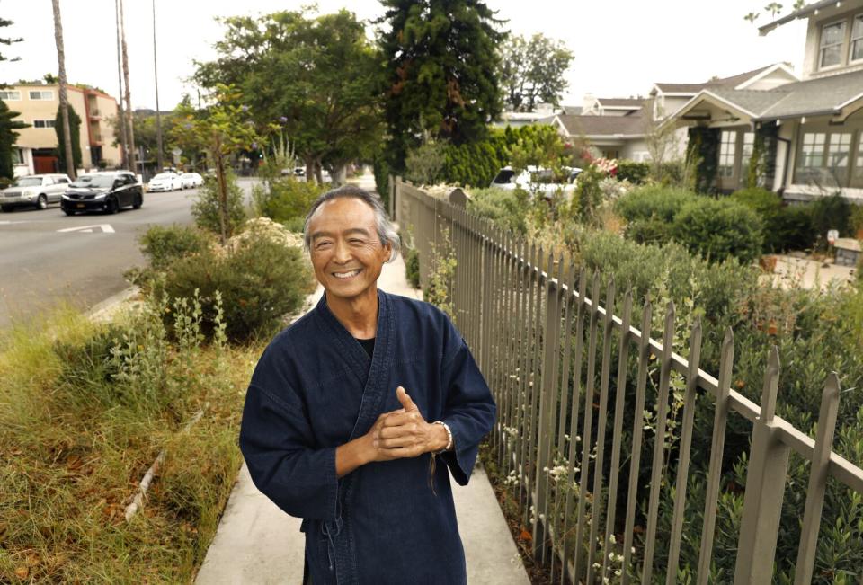 Georg Kochi stands on the sidewalk in front of his Koreatown Craftsman home.