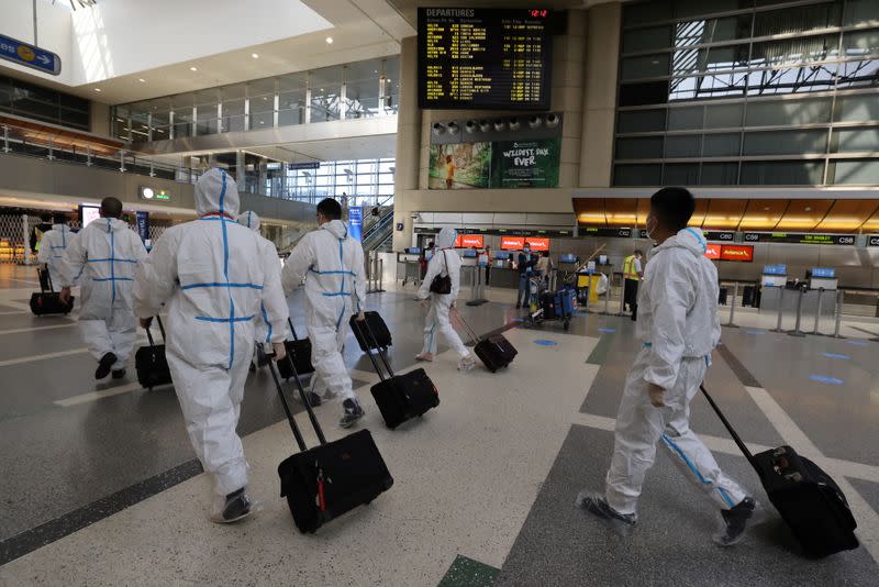 A flight crew walks through Tom Bradley international terminal at LAX airport, as the global outbreak of the coronavirus disease (COVID-19) continues, in Los Angeles