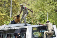 A policeman drags a supporter of opposition Congress party atop a police vehicle as they are detained while protesting against their leader Rahul Gandhi's expulsion from Parliament in New Delhi, India, Monday, March 27, 2023. Gandhi was expelled from Parliament a day after a court convicted him of defamation and sentenced him to two years in prison for mocking the surname Modi in an election speech. (AP Photo/Deepanshu Aggarwal)