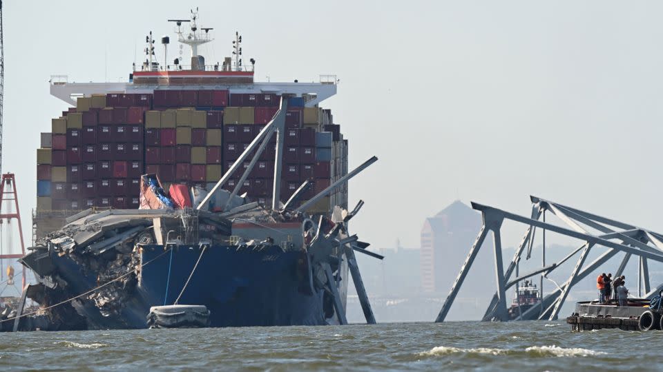 A section of the Francis Scott Key Bridge rests in the water next to the Dali container ship in Baltimore on Monday after crews conducted a controlled demolition. - Roberto Schmidt/AFP/Getty Images