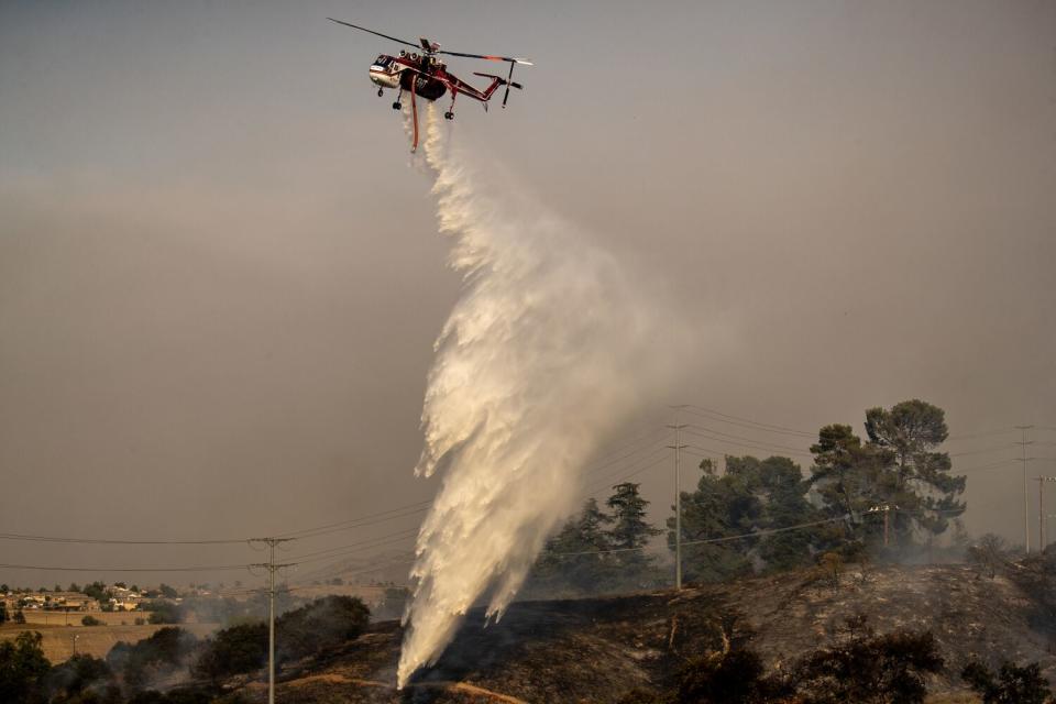 A helicopter makes a water drop.