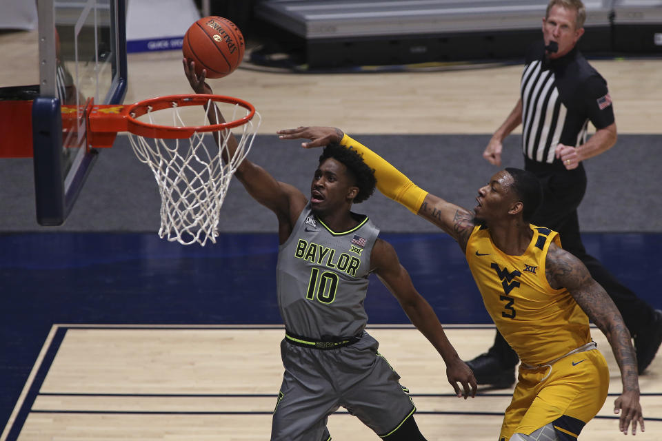 Baylor guard Adam Flagler (10) shoots while defended by West Virginia forward Gabe Osabuohien (3) during the second half of an NCAA college basketball game Tuesday, March 2, 2021, in Morgantown, W.Va. (AP Photo/Kathleen Batten)