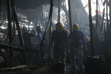 Fire investigators inspect a mall gutted by fire in Davao city, Philippines, December 29, 2017. REUTERS/Lean Daval Jr