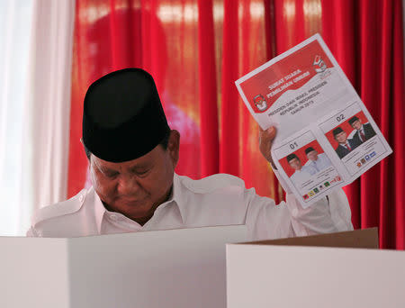 Indonesian presidential candidate Prabowo Subianto holds up his ballot paper at a polling booth during elections in Bogor, West Java, Indonesia April 17, 2019. REUTERS/Willy Kurniawan