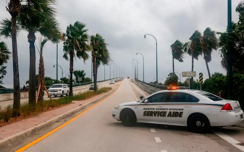 Authorities block a road in Jensen Beach, Florida  - Credit: ADAM DELGIUDICE/AFP