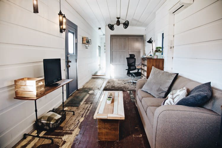 Adrienne decided against the black Sherwin Williams paint she bought to cover the original dark-rust floors, and let the floor’s character bleed through. Photo credit: Airbnb.