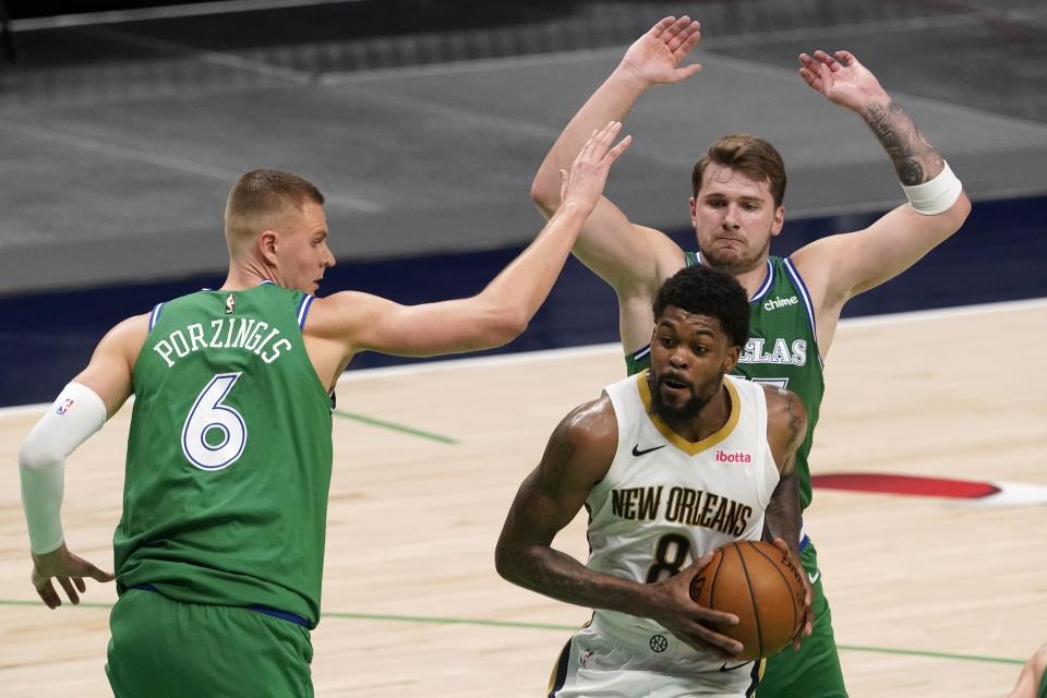 Dallas Mavericks' Kristaps Porzingis (6) and Luka Doncic, rear, defend as New Orleans Pelicans forward Naji Marshall (8) works for a shot during the second half of an NBA basketball game in Dallas, Wednesday, May 12, 2021. (AP Photo/Tony Gutierrez)