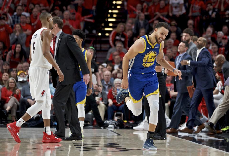 Golden State Warriors guard Stephen Curry, right, reacts after making a 3-point basket against the Portland Trail Blazers during the second half of Game 4 of the NBA basketball playoffs Western Conference finals Monday, May 20, 2019, in Portland, Ore. The Warriors won 119-117 in overtime. (AP Photo/Craig Mitchelldyer)