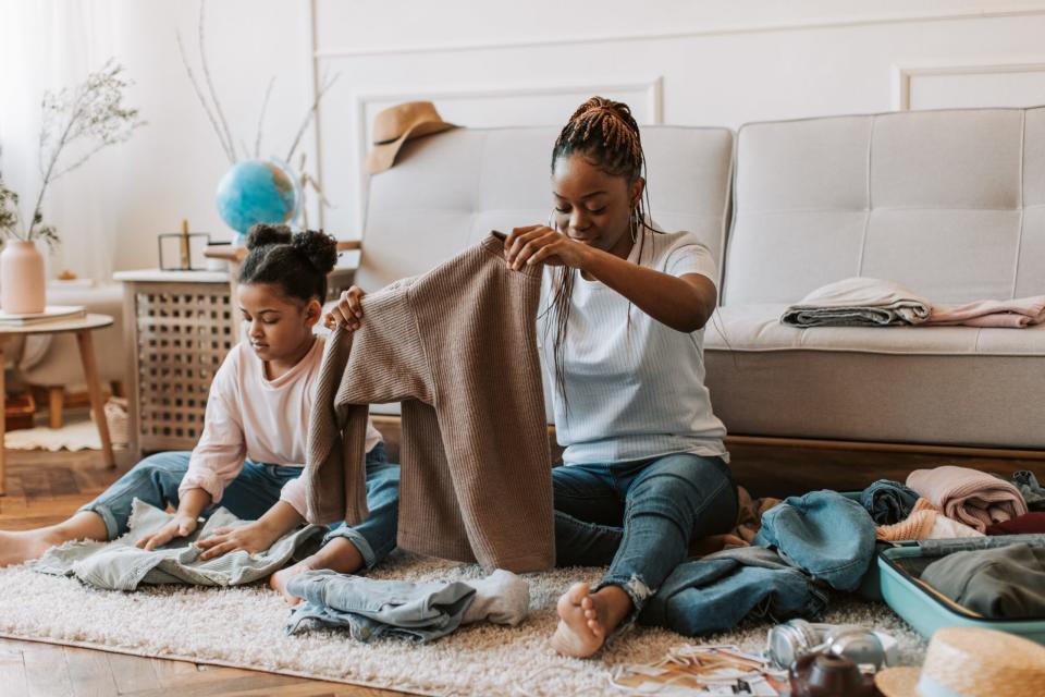 A Black woman and little girl packing a suitcase