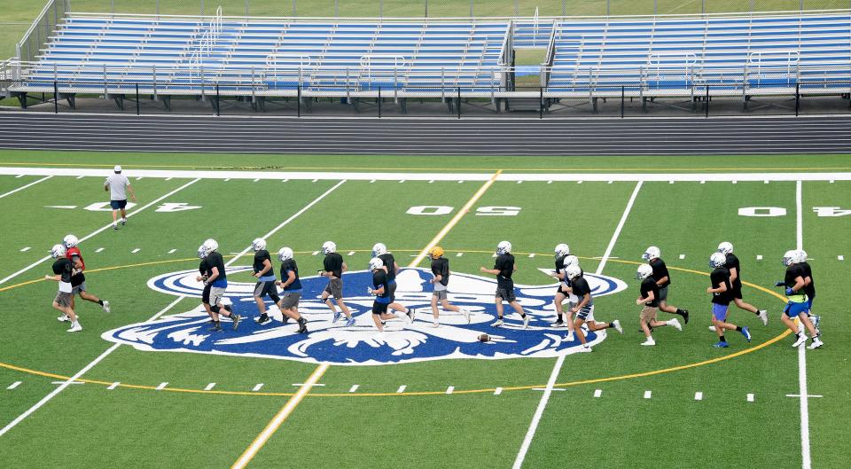 The Dundee Vikings logo is the centerpiece as the varsity football team line-up for offensive drills recently inside the new John D. Craig and Family Athletic Complex.