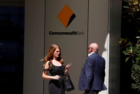 FILE PHOTO: Office workers walk in front of the Commonwealth Bank of Australia building in central Sydney