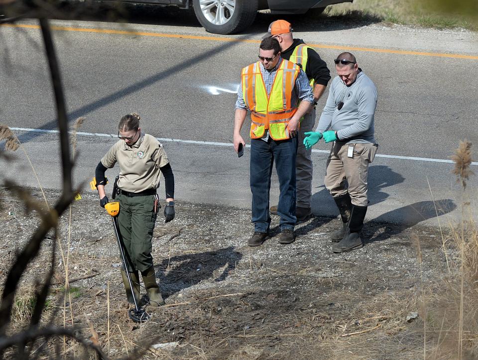 Investigators comb over the ground near where a body was found on Exit 94 to I-55 South in Springfield Wednesday, March 13, 2024.