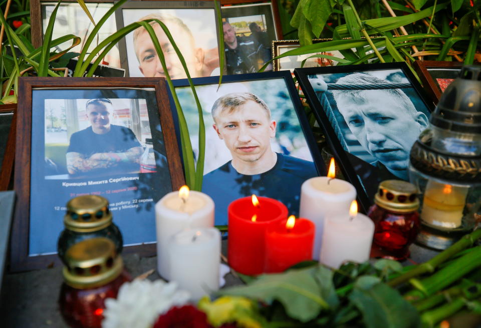 Candles are placed next to the portraits of Vitaly Shishov, a Belarusian activist living in exile who was found hanged in a park near his home this morning, during a commemoration rally next to the Belarusian Embassy to Ukraine in Kyiv, Ukraine August 3, 2021. REUTERS/Gleb Garanich