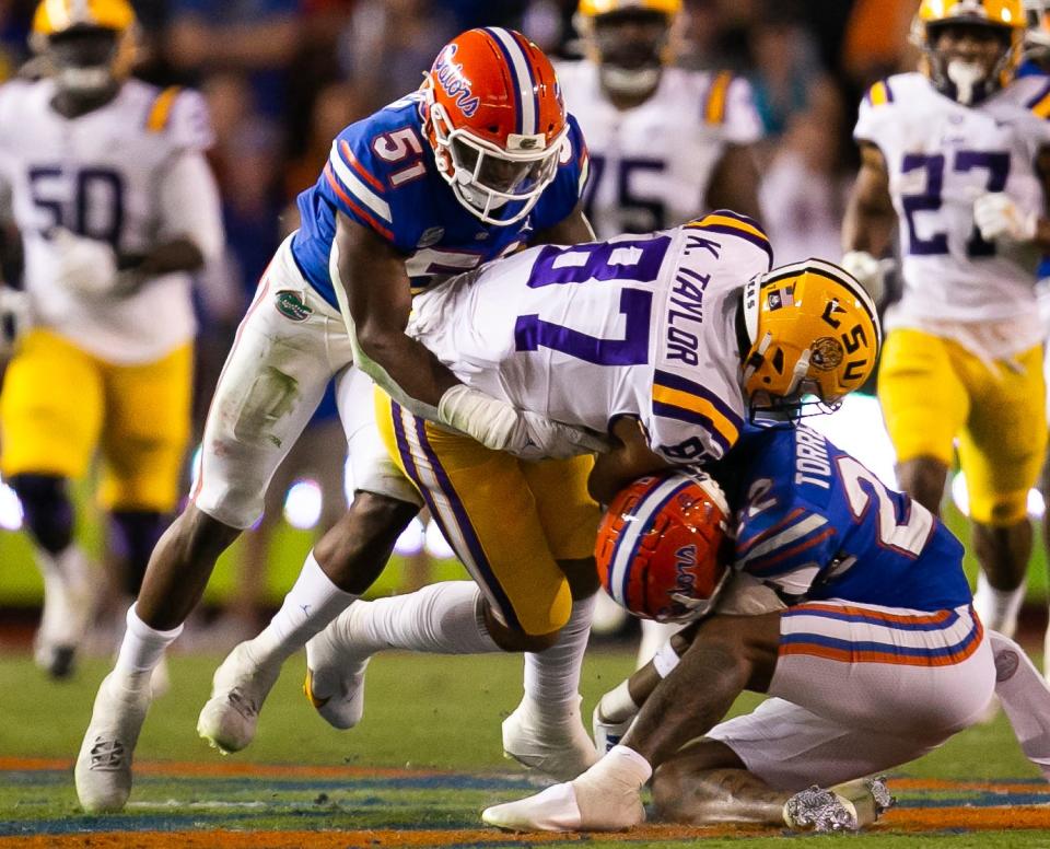 LSU Tigers tight end Kole Taylor (87) is stopped by Florida Gators linebacker Ventrell Miller (51) and Florida Gators safety Rashad Torrence II (22) in the firs half at Steve Spurrier Field at Ben Hill Griffin Stadium in Gainesville, FL on Saturday, October 15, 2022. [Doug Engle/Gainesville Sun]