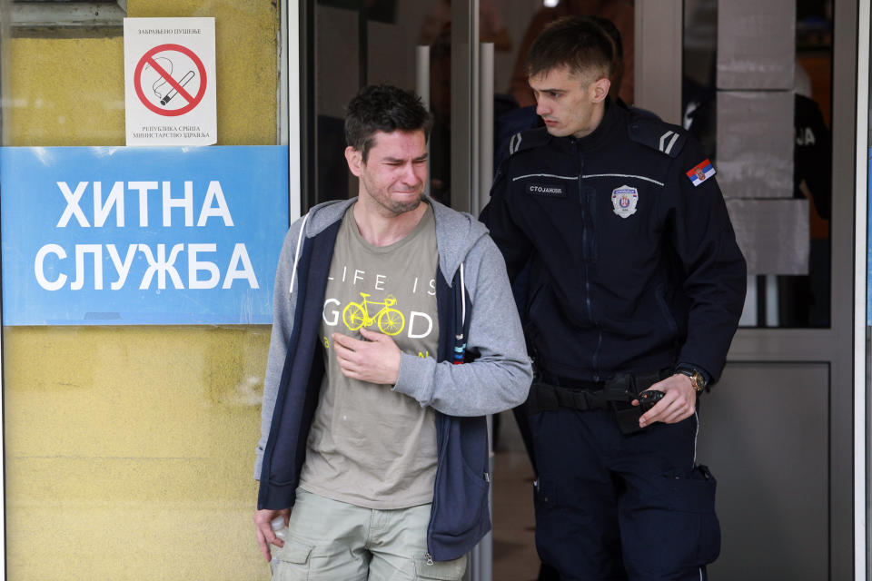 A man cries at the entrance of a hospital in Belgrade, Serbia, Wednesday, May 3, 2023. Serbian police say a teenage boy opened fire at a school in central Belgrade, killing several children and hospitalizing several more. (AP Photo/Milos Miskov)