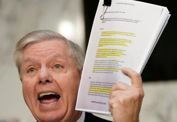 Lindsey Graham brandishes a copy of the Steele dossier while questioning Mr Horowitz (Getty Images)