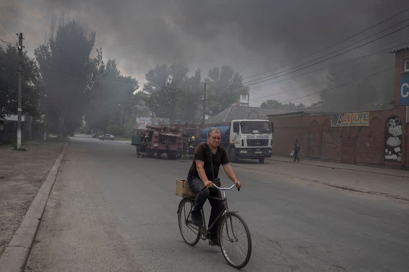 Un hombre monta una bicicleta a lo largo de una calle en el mercado tras los bombardeos, mientras continúa el ataque de Rusia contra Ucrania, en Sloviansk, región de Donetsk, Ucrania