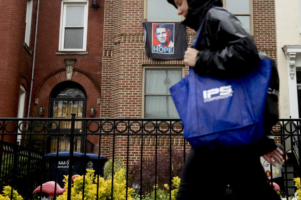 In this May 22, 2020, photo, an image of Director of the National Institute of Allergy and Infectious Diseases Dr. Anthony Fauci with the word "Hope" hangs from the window of a row house in Washington. As a candidate for the White House, President Donald Trump once said he wanted “whatever is best” for the residents of the nation’s capital. But over the course of his more than three years in office a disconnect between the president and District of Columbia has emerged -- a chasm that has only grown during the coronavirus pandemic. (AP Photo/Andrew Harnik)