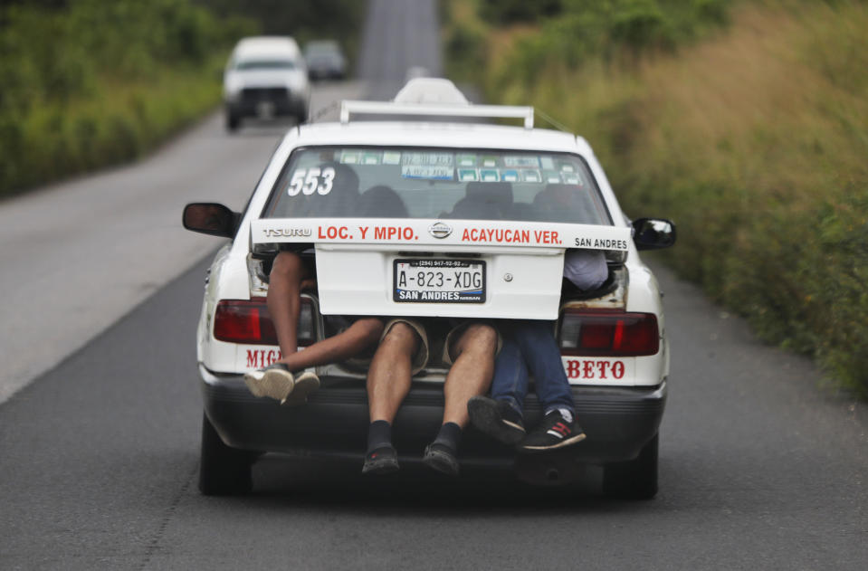 FILE - In this Nov. 3, 2018 file photo, Central American migrants from a U.S.-bound caravan get a free ride in the trunk of a taxi in Acayucan, Veracruz state, Mexico. It is unclear what part of the U.S. border they will aim for eventually, but their latest overnight stay in Veracruz could be one of their last before they head to Mexico City, a potential launching spot for a broader array of destinations. (AP Photo/Marco Ugarte, File)