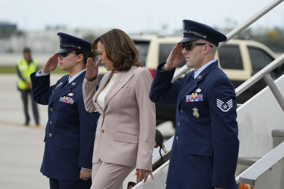 Vice President Kamala Harris salutes soldiers standing beside the plane steps as she arrives at Miami International Airport, Friday, April 21, 2023, in Miami. Harris traveled to Miami on Friday to announce funding for climate change resiliency projects across the U.S. (AP Photo/Rebecca Blackwell)