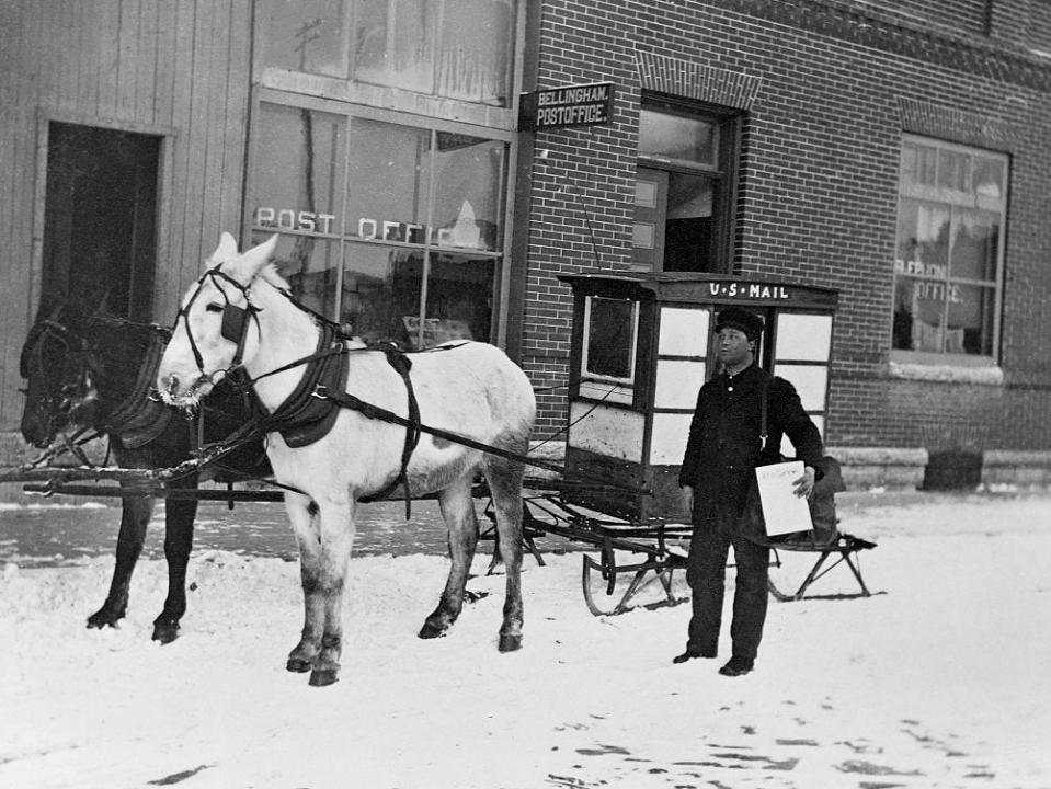 A postal worker uses a horse-drawn sleigh