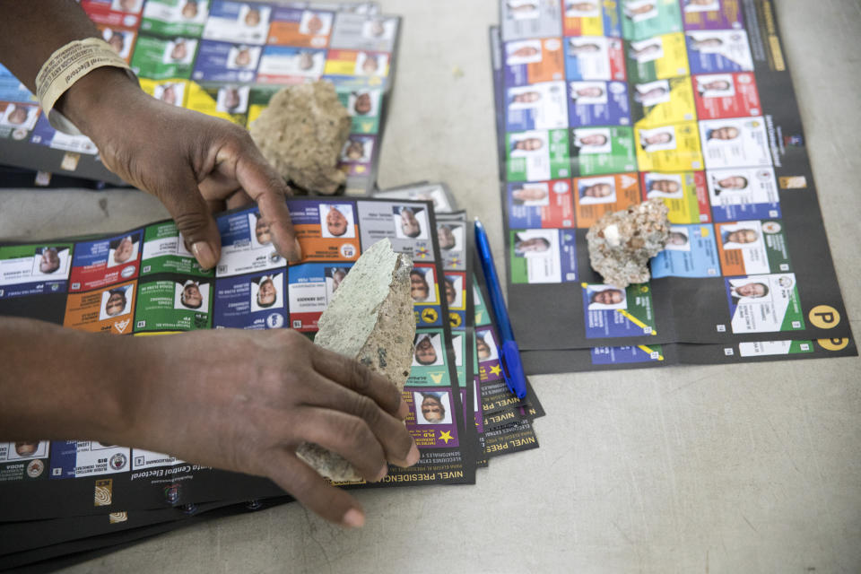 Piedras utilizadas como pisapapeles para evitar que se vuelen las papeletas mientras autoridades electorales cuentan votos tras el cierre de urnas en las elecciones presidenciales, en Santo Domingo, República Dominicana, el domingo 5 de julio de 2020. (AP Foto/Tatiana Fernández)