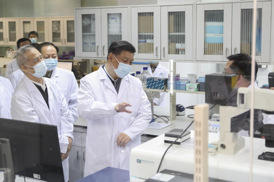 In this Monday, March 2, 2020, photo released by Xinhua News Agency, Chinese President Xi Jinping, centre, wearing a protective face mask, talks to a medical staff member during his visit to the Academy of Military Medical Sciences in Beijing. As the rest of the world grapples with a burgeoning virus outbreak, China's ruling Communist Party has turned to its propaganda playbook to portray its leader as firmly in charge, leading an army of health workers in a "people's war" against the disease. (Ju Peng/Xinhua via AP)