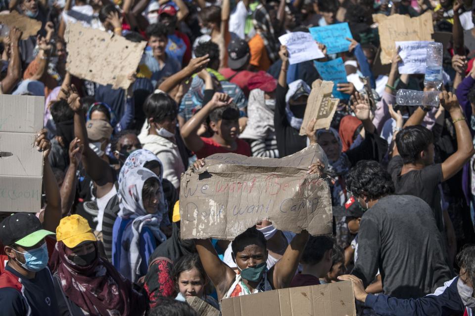 Migrants take part in a rally near Mytilene town, on the northeastern island of Lesbos, Greece, Friday, Sept. 11, 2020. Thousands of protesting refugees and migrants left homeless on the Greek island of Lesbos after fires destroyed the notoriously overcrowded Moria camp have gathered on a road leading to the island's main town, demanding to be allowed to leave. (AP Photo/Petros Giannakouris)