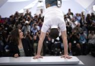 Billie Blain, left, reacts as Tom Mercer performs a handstand at the photo call for the film 'Le Regne animal' at the 76th international film festival, Cannes, southern France, Thursday, May 18, 2023. (AP Photo/Daniel Cole)
