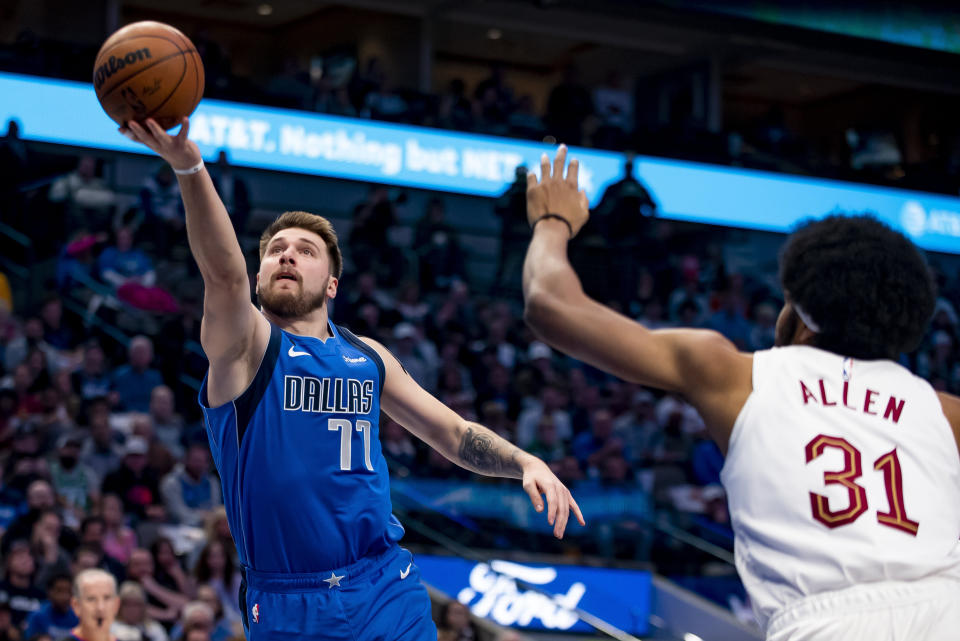 Dallas Mavericks guard Luka Doncic (77) shoots a layup while Cleveland Cavaliers center Jarrett Allen (31) attempts to defend in the first half of an NBA basketball game in Dallas, Wednesday, Dec. 14, 2022. (AP Photo/Emil Lippe)