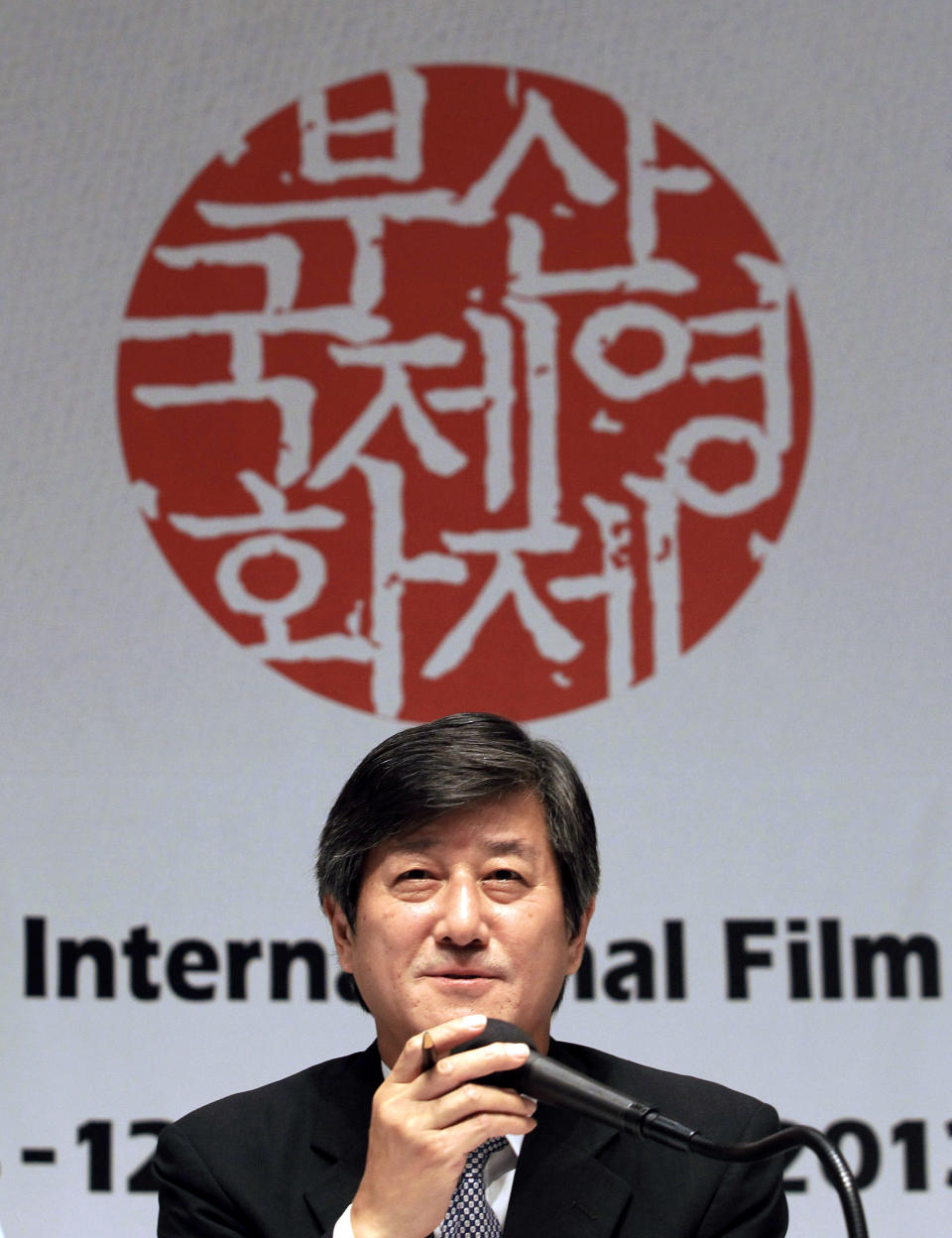 Lee Yong-kwan, director of the Busan International Film Festival, speaks during a press conference in Seoul, South Korea, Tuesday, Sept. 3, 2013. The festival will be held at the Busan Cinema Center and seven other movie theaters in the southern port city of Busan from Oct. 3-12. The letters read " The Busan International Film Festival". (AP Photo/Ahn Young-joon)