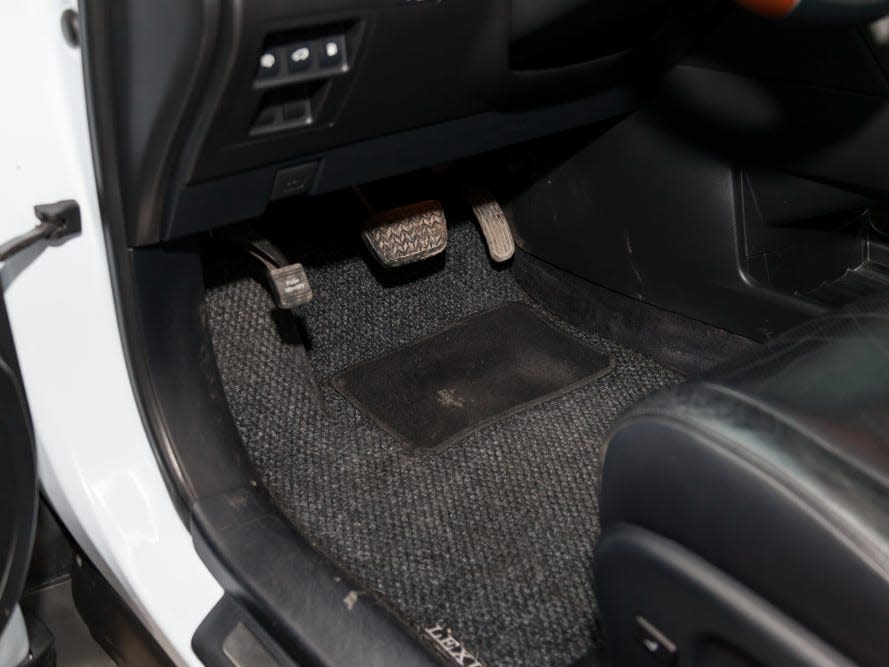A car floor mat near the gas and brake pedals.