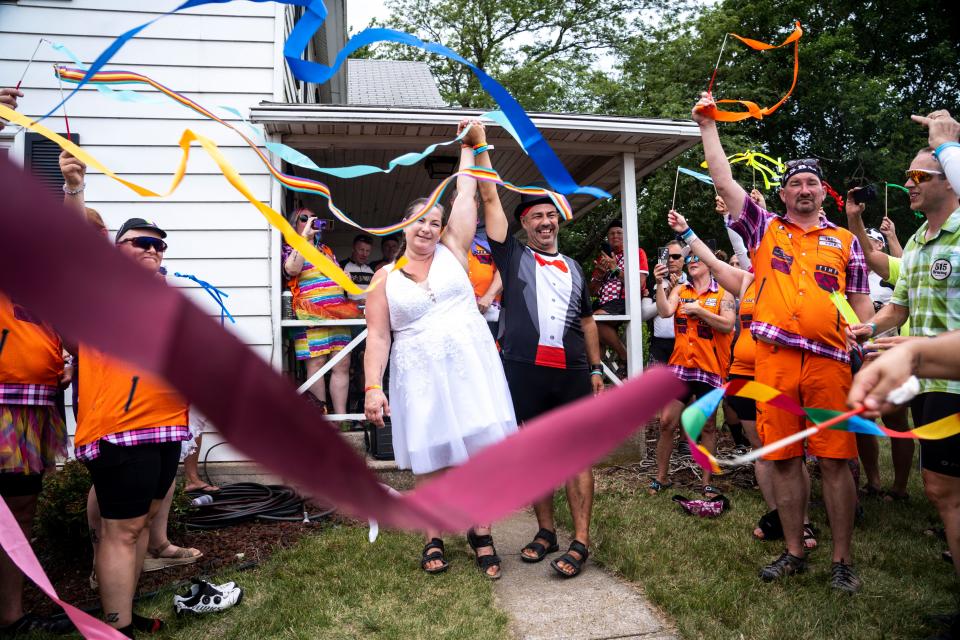 RAGBRAI riders Jamie and Joe Stacey walk hand-in-hand after their wedding at the Iowa Craft Beer Tent on Tuesday, July 25, 2023, near Luther.