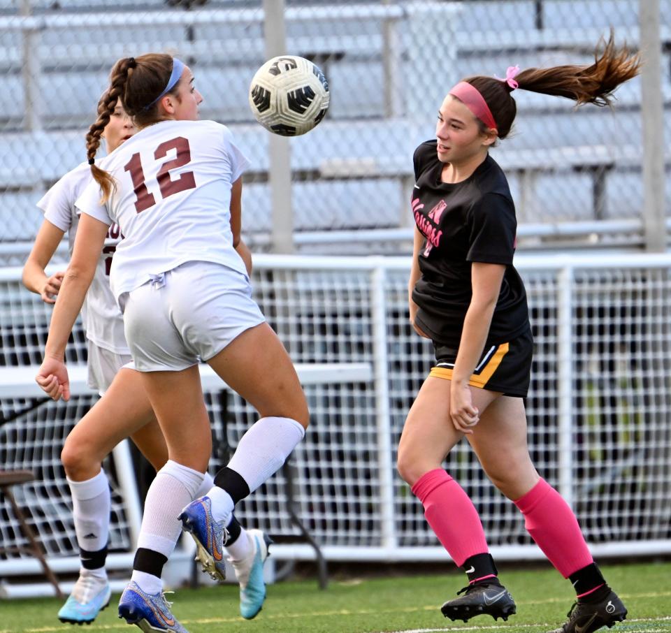 Camille Femino of Falmouth heads the ball away from Molly Farrell of Nauset.