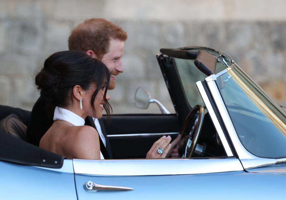 Britain's Prince Harry, Duke of Sussex, (R) and Meghan Markle, Duchess of Sussex, (L) leave Windsor Castle in Windsor on May 19, 2018 in an E-Type Jaguar after their wedding to attend an evening reception at Frogmore House. (Photo by Steve Parsons / POOL / AFP)        (Photo credit should read STEVE PARSONS/AFP via Getty Images)