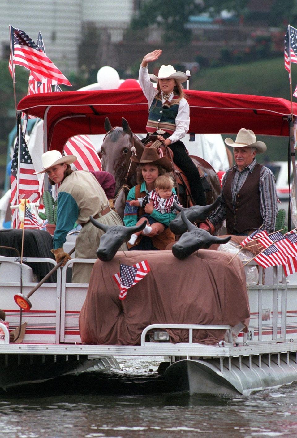 Stephanie Summers, 10, of Suffield Township, waves from astride the horse manikin on her grandparents' Wild West=themed boat in 1998.