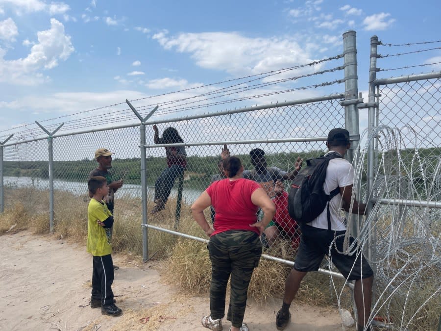 A group of migrants enter a gap in the concertina wire along the border in Eagle Pass, Texas, on Aug. 21, 2023. (Sandra Sanchez/Border Report)