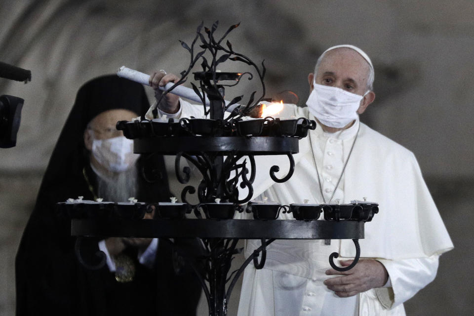 Pope Francis lights a candle for peace during an inter-religious ceremony for peace in the square outside Rome's City Hall, Tuesday, Oct. 20, 2020 (AP Photo/Gregorio Borgia)