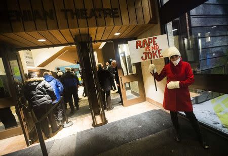 A woman protests against Bill Cosby, outside the Centre In The Square venue where the comedian is performing, in Kitchener, January 7, 2015. REUTERS/Mark Blinch