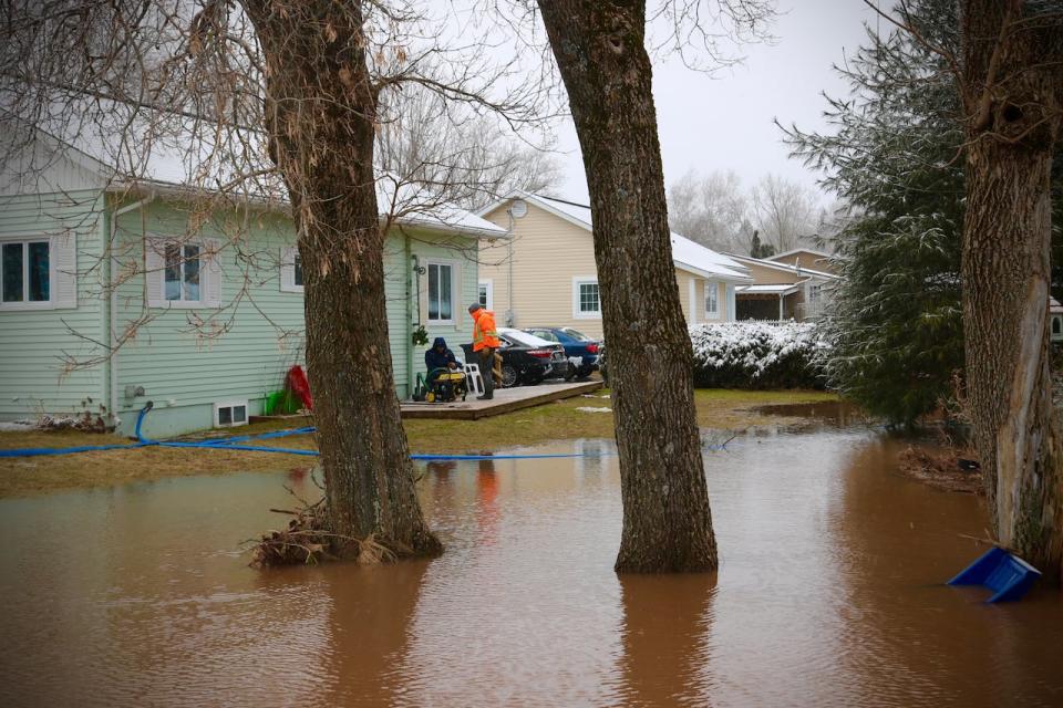 Residents pump out water last Thursday at a home just off Stewart Ave. 