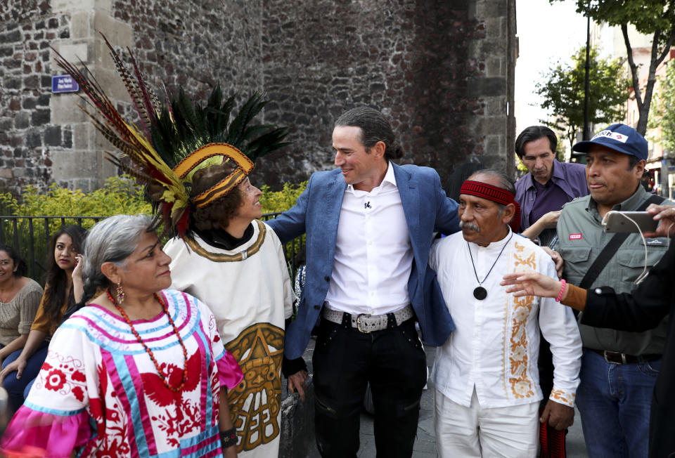 Italian Ascanio Pignatelli of the 16th generation descended from Hernan Cortes' daughter, poses for a picture with Aztec dancers in Mexico City, Friday, Nov. 8, 2019. Descendants of the Spanish conquistador Hernan Cortes and the Aztec emperor Moctezuma are meeting in Mexico City to mark the 500th anniversary of their forbearers' first encounter. (AP Photo/Eduardo Verdugo)