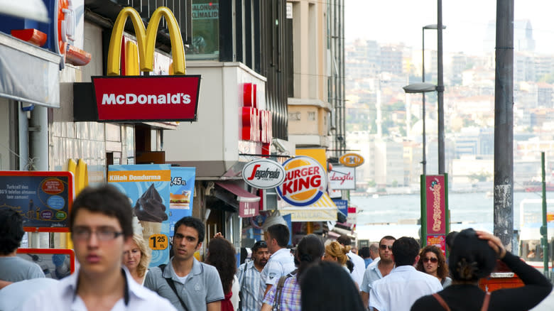 People in a city walk past a McDonald's