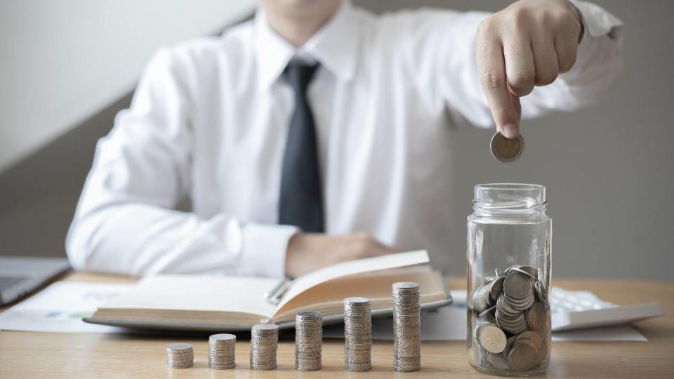 Un employé de bureau dépose une pièce dans un vase