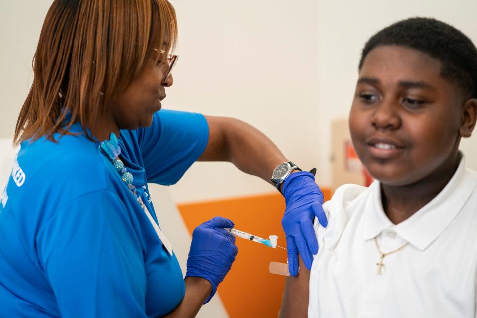 DMC medical office assistant Saundra Logan, 47, of Detroit, administers one of three vaccines that Caleb Holmes, 12, of Detroit, received during a visit by Director of the Centers for Disease Control, Dr. Mandy Cohen, to the DMC Children's Hospital of Michigan Specialty Center in Detroit on Tuesday, July 23, 2024.