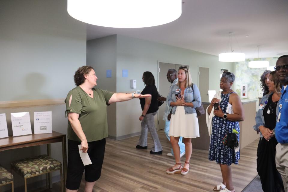 At left, Holly Klein, executive director of Grace House Akron, shows supporters and volunteers around the new facility on Friday.