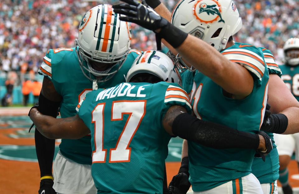 Teammates congratulate Jaylen Waddle for his touchdown against the Patriots.