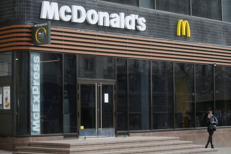 FILE PHOTO: A woman speaks on the phone outside a closed McDonald's restaurant in Kyiv