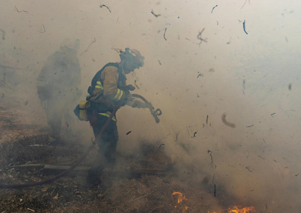Firefighters from San Matteo work to extinguish flames from the Kincade Fire in Sonoma County, Calif., Oct. 27, 2019. (AP Photo/Ethan Swope)