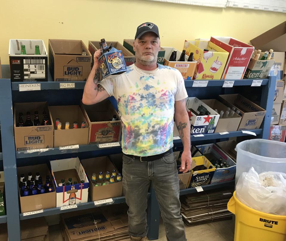 Town Line Redemption Center in Dighton employee Tim Moore displays some of the bottles that he gathers for shipment to distributors while at work on Wednesday, Feb. 8, 2023.